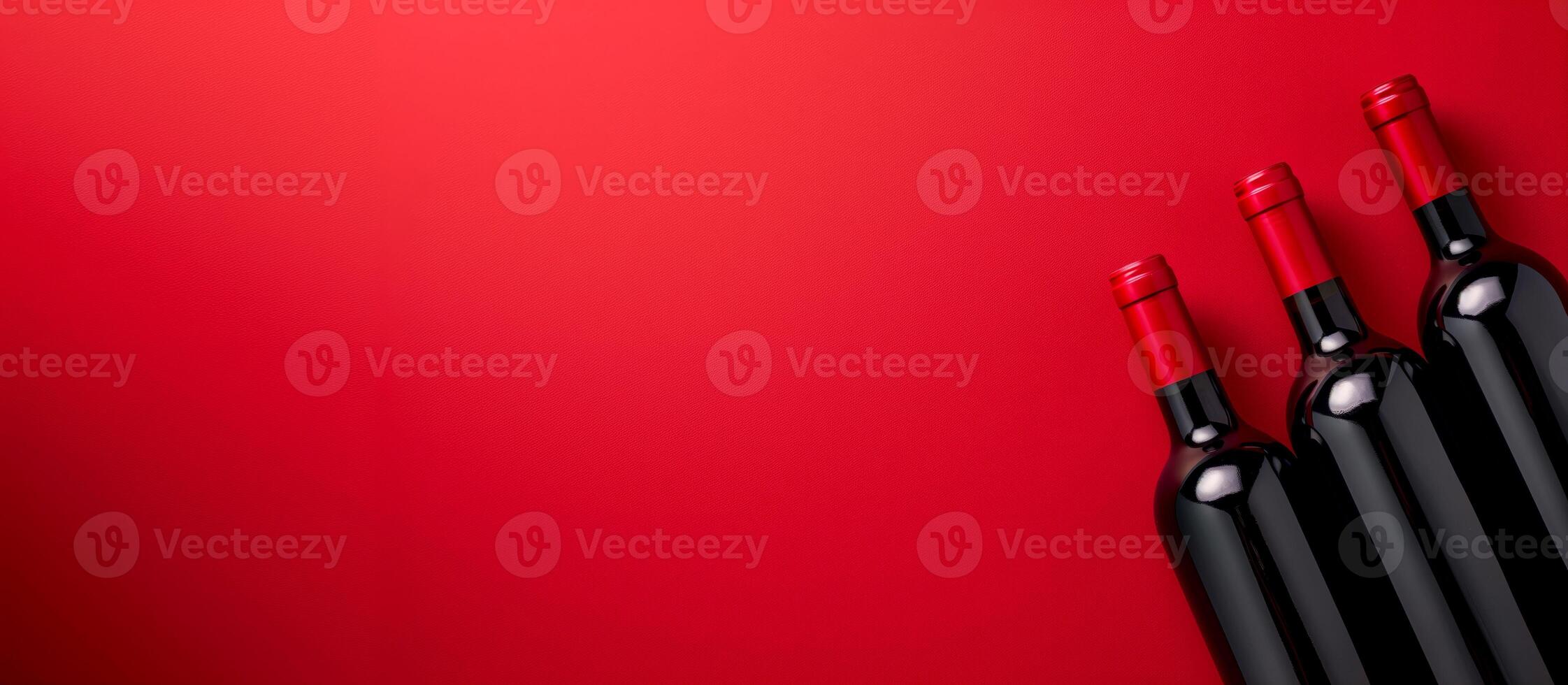 Three bottles of wine on a red background with copy space photo