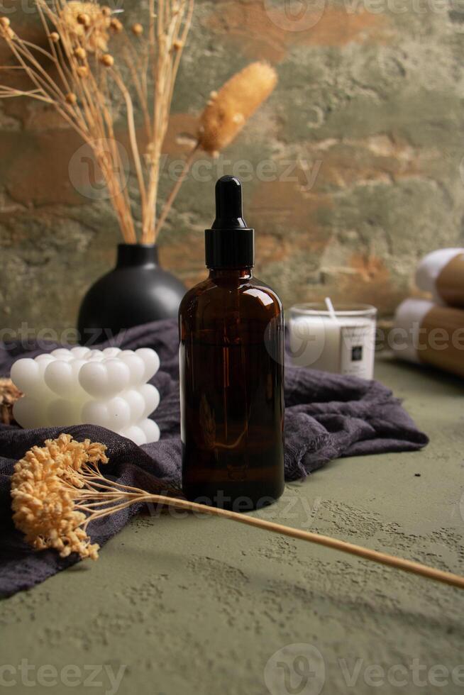 Amber Dropper Bottle with Dried Flowers and Bubble Candle for Spa Decor photo