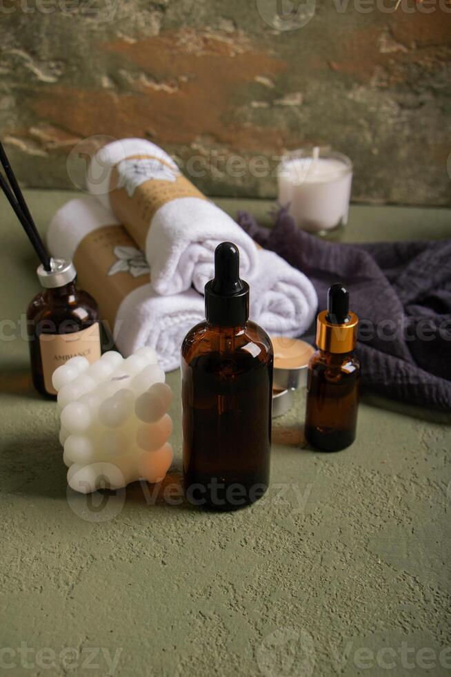 Spa and Wellness Essentials with Amber Dropper Bottles, Towels, and Candles photo