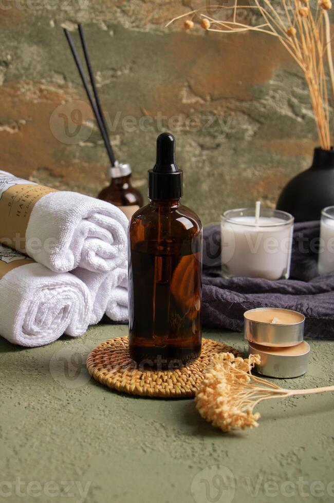 Amber Dropper Bottle with Candles, Towels, and Dried Flowers for Spa Decor photo