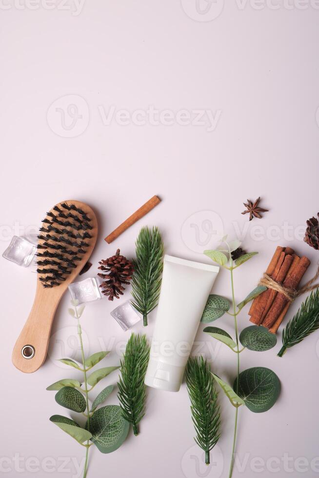 Organic Skincare Tube with Botanical and Wooden Accessories on White Background photo