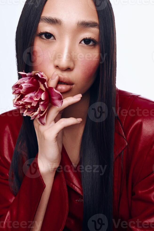 Woman with Black Hair and Red Jacket Holding Flower in Front of Her Face in Studio Portrait Photo