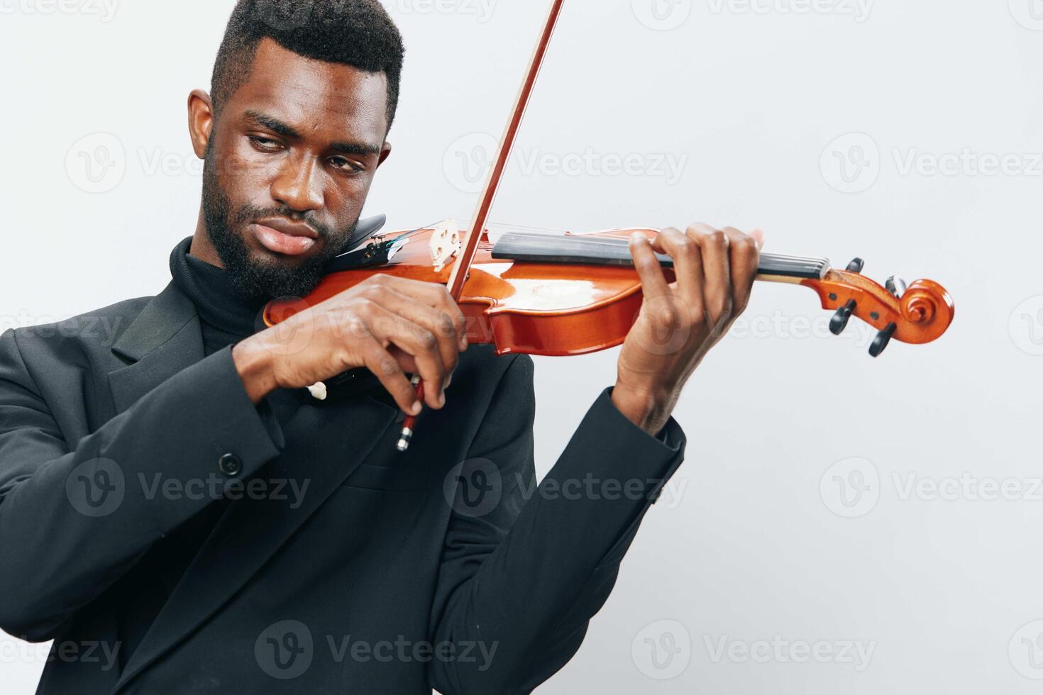 Talented African American man in a suit playing the violin with passion on a white background photo