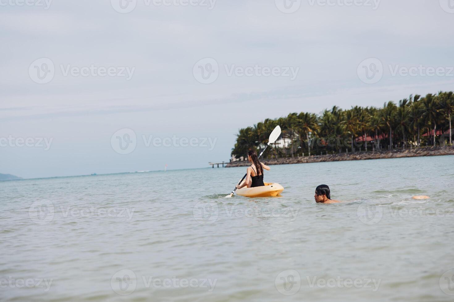 Floating Fun. Active Asian Couple Kayaking on a Tropical Lake, Embracing Adventure and Togetherness photo