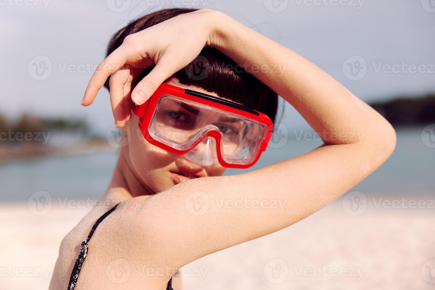 Joyful Woman Snorkeling in Red Fashion Swimsuit, Smiling at Camera against Tropical Beach Background photo
