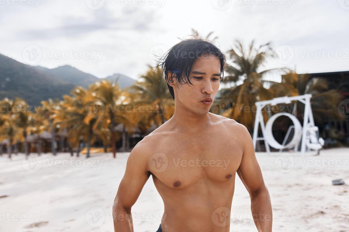 Muscular Asian Man Enjoying Sunset Beach Run. Freedom and Strength photo
