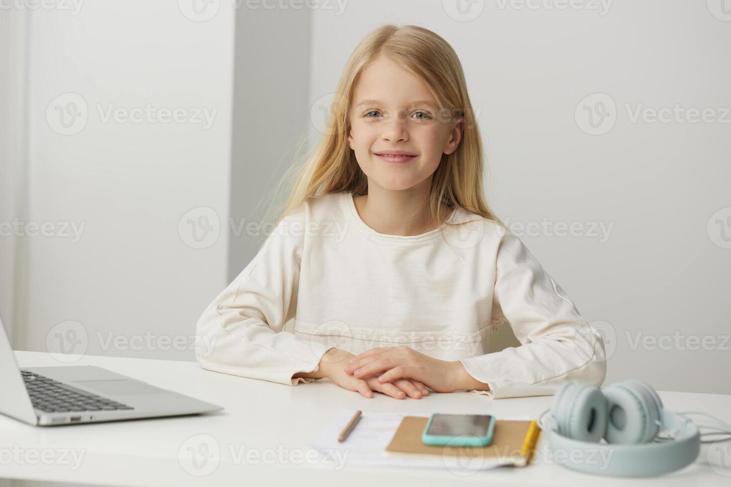 Smiling girl learning online using laptop for elearning at home She is a cute, young student sitting photo