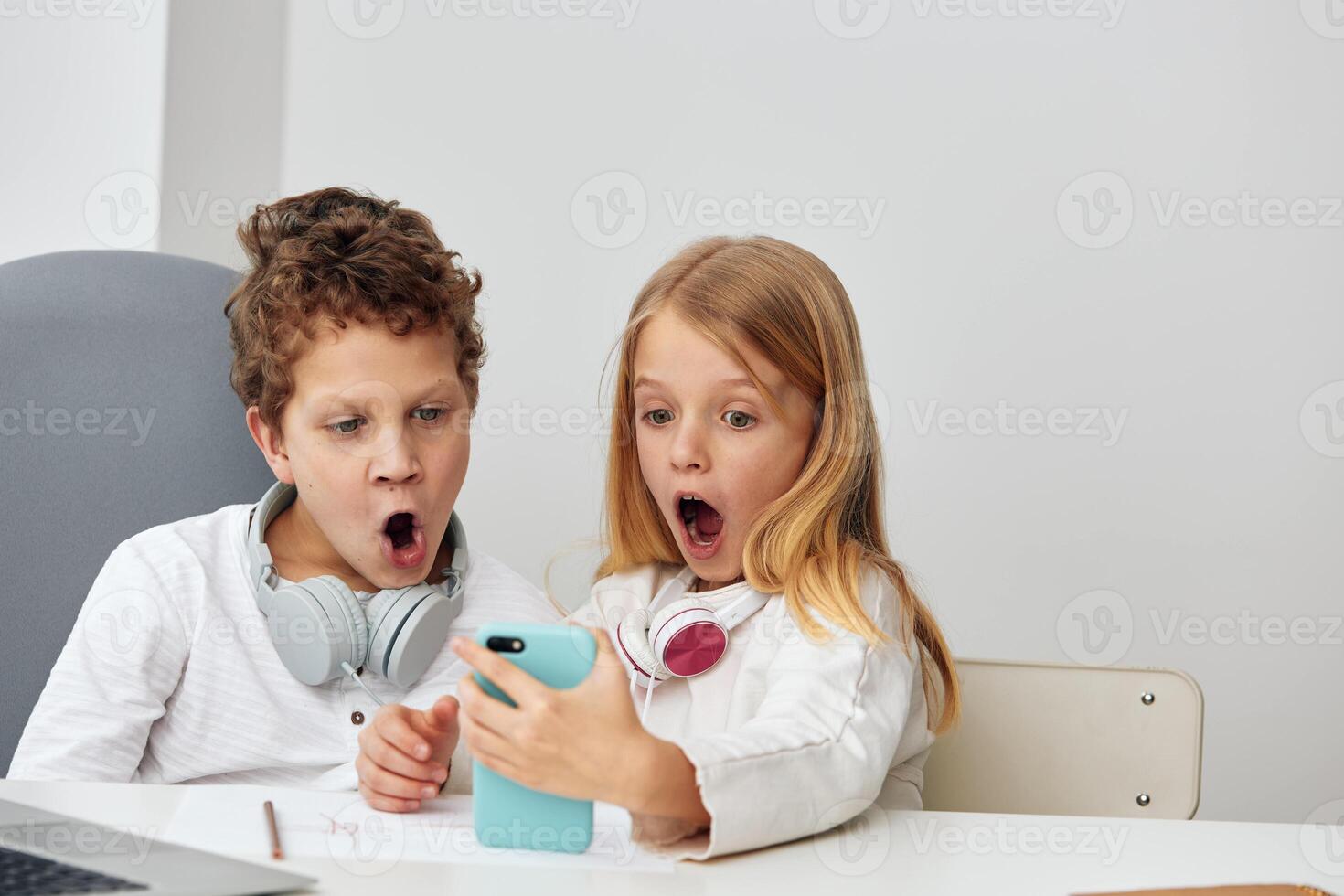 Happy Caucasian school student playing and studying online at home Sitting at a desk in the living photo