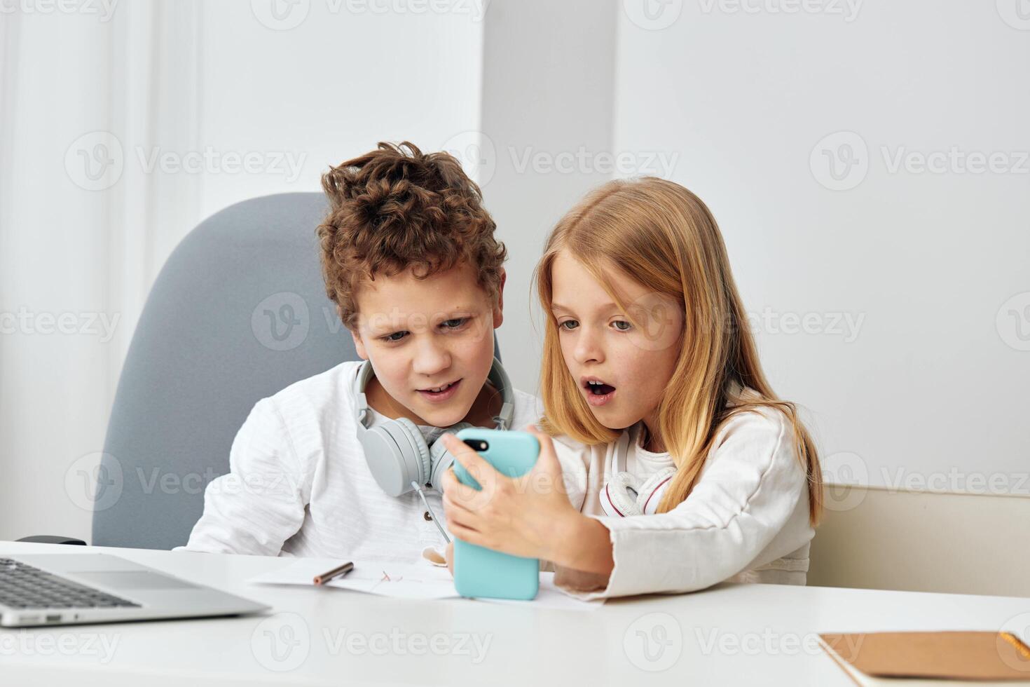 Teenage boy and girl studying together using laptops at home They are happy and engaged in online photo