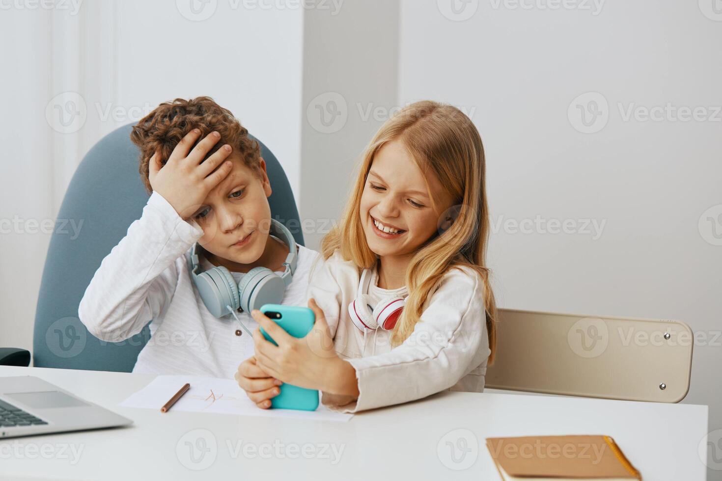 Happy Children Engaged in Online Learning Boy and Girl Studying with Laptops at Home photo