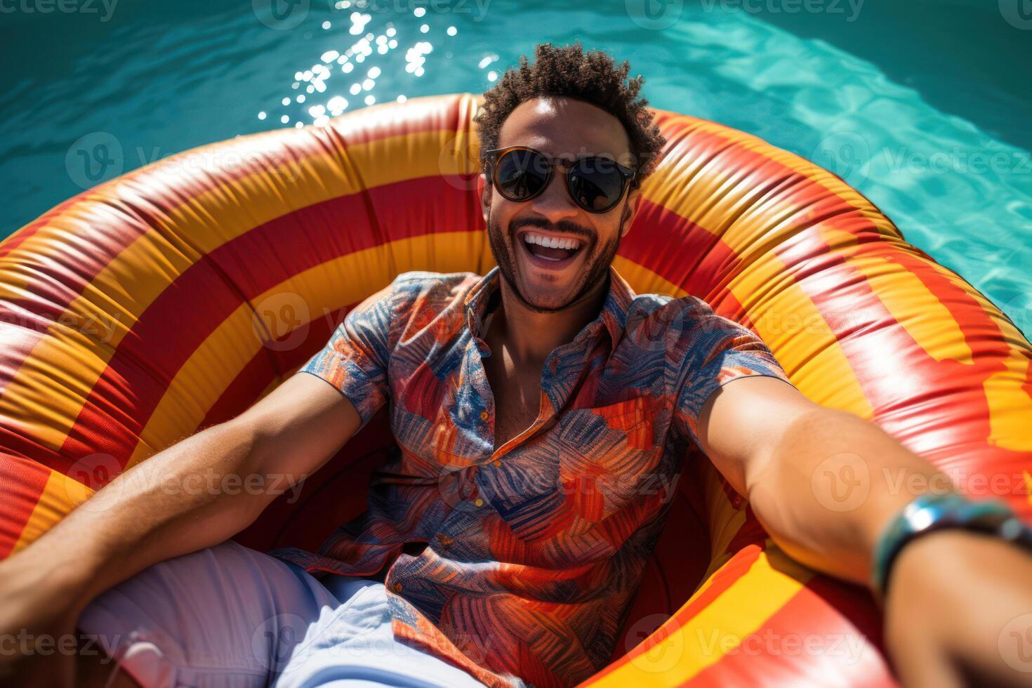 Happy Summer Leisure. A Handsome Male Smiling in Sunglasses on a Blue Pool Mattress photo