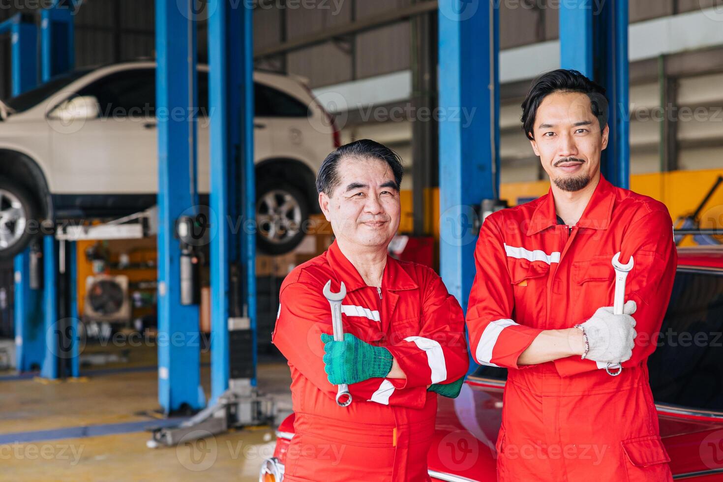 Portrait Asian Japanese male mechanic workers team in auto service workshop car maintenance center replace fix auto engine part photo