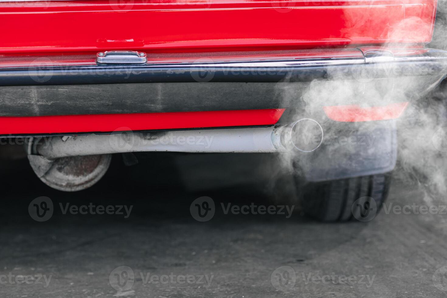 closeup old car rear exhaust pipe with smell smoke carbon monoxide bad air pollution lung disease photo