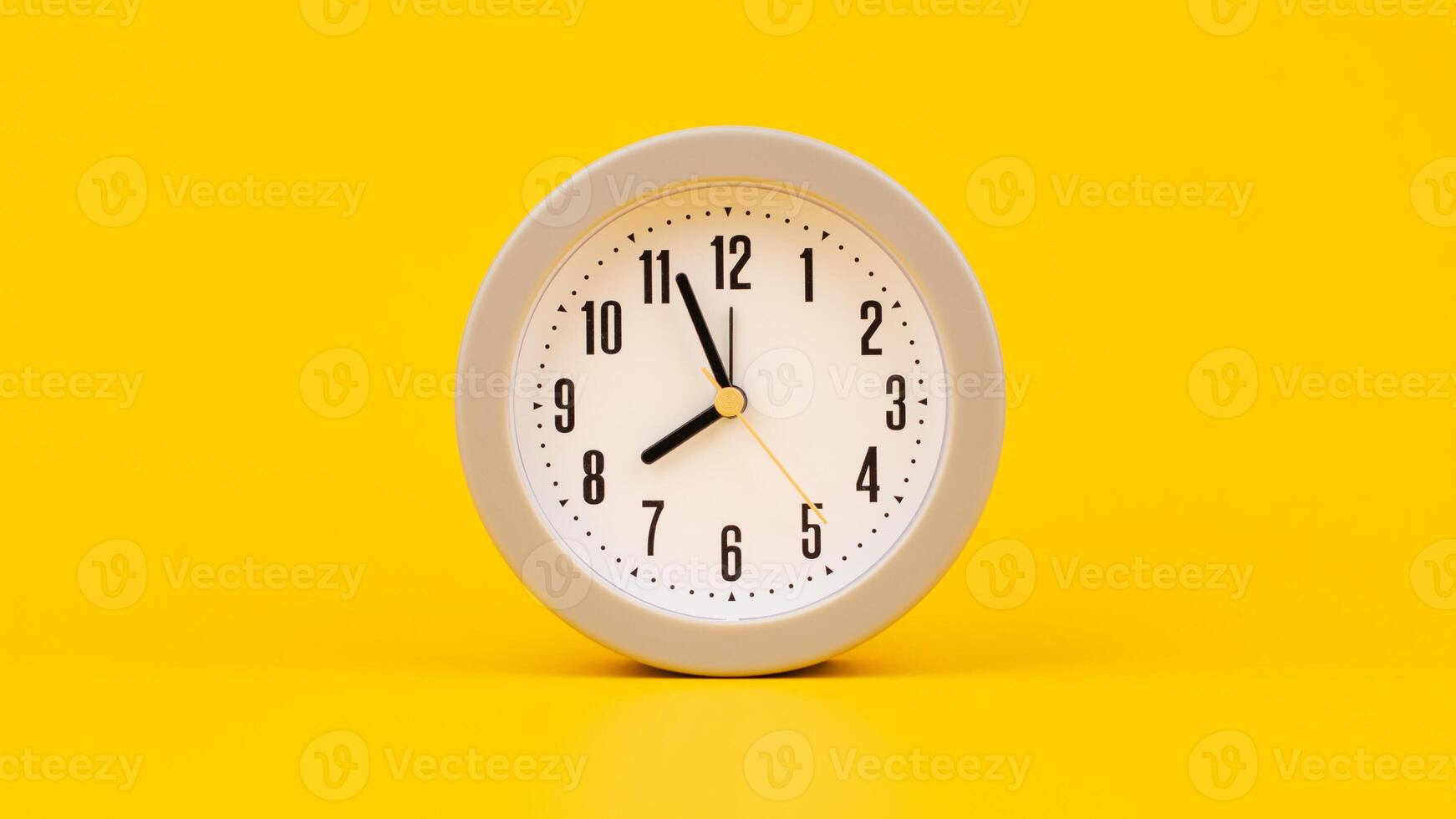 Time and work, the clock stops, the minute hand stops moving, a photo of a clock on a yellow background.