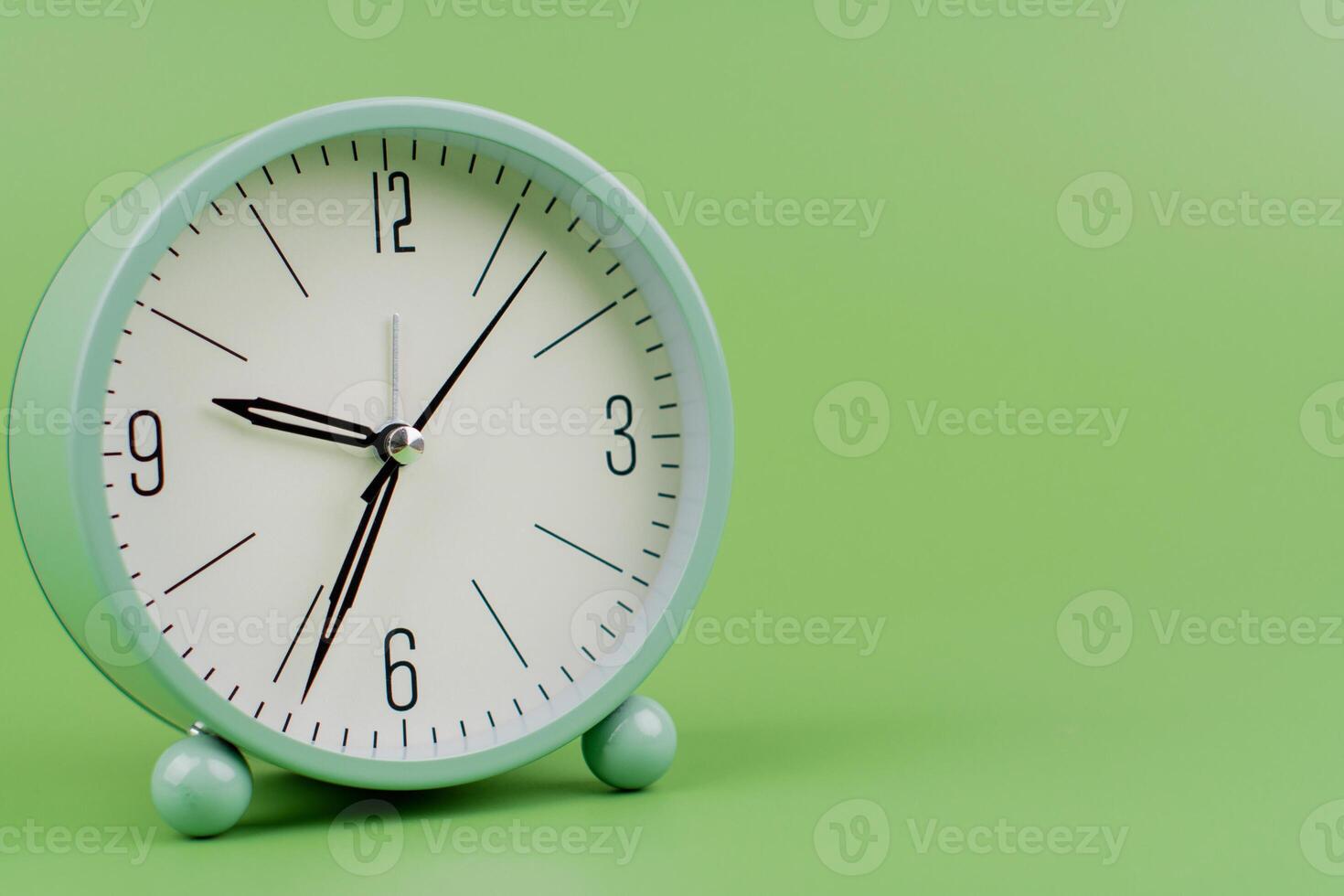 Time, standing still, time hand, photo of a moving clock on a green background, time concept.
