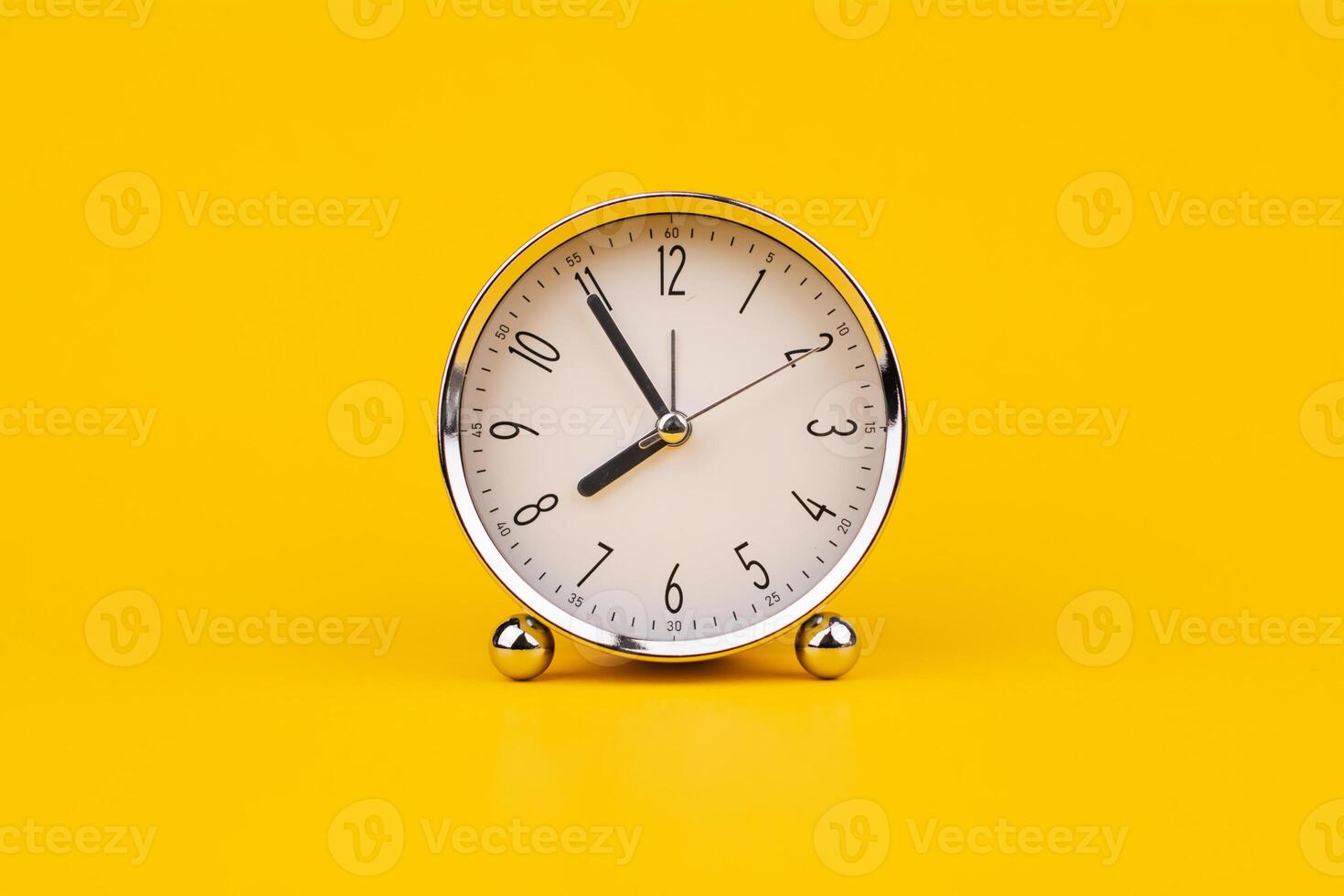 Time and work, the clock stops, the minute hand stops moving, a photo of a clock on a yellow background.