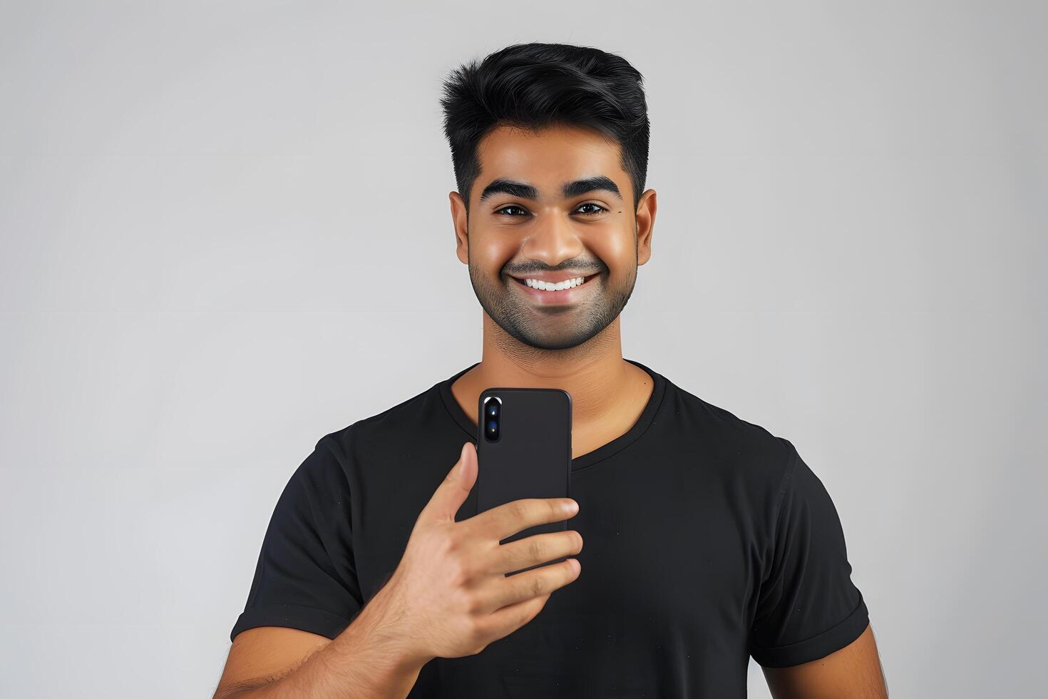 Portrait of happy young indian man using mobile phone and showing thumbs up photo