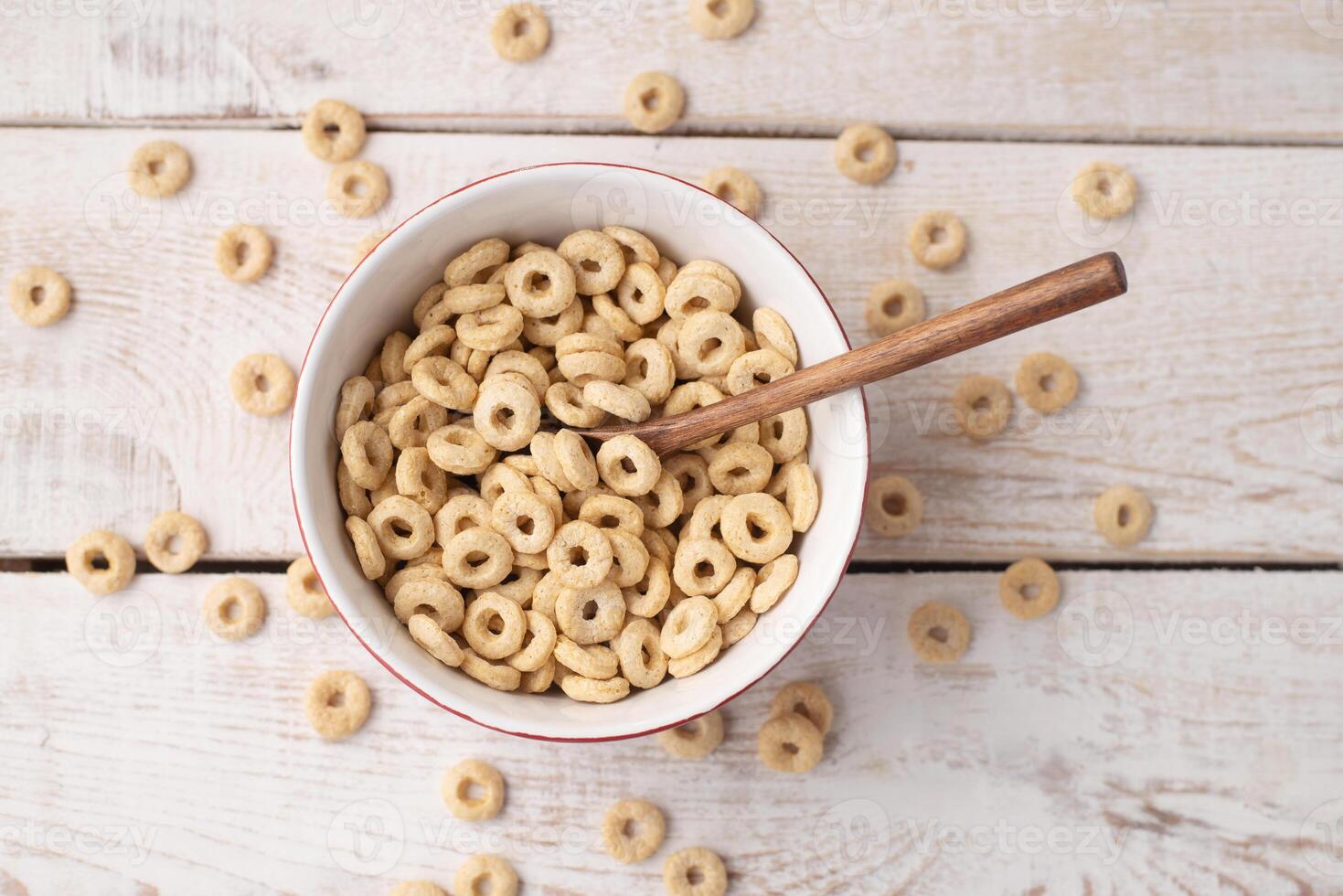 healthy cereal rings on a light wood background in a plate and scattered on the table. morning eat. Healthy children's breakfast. Dry muesli. photo