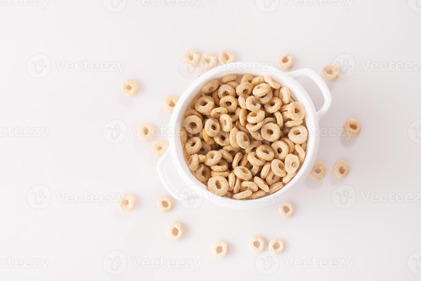 healthy cereal rings on a white background in a plate and scattered on the table. morning eat. Healthy children's breakfast. Dry muesli. top view photo