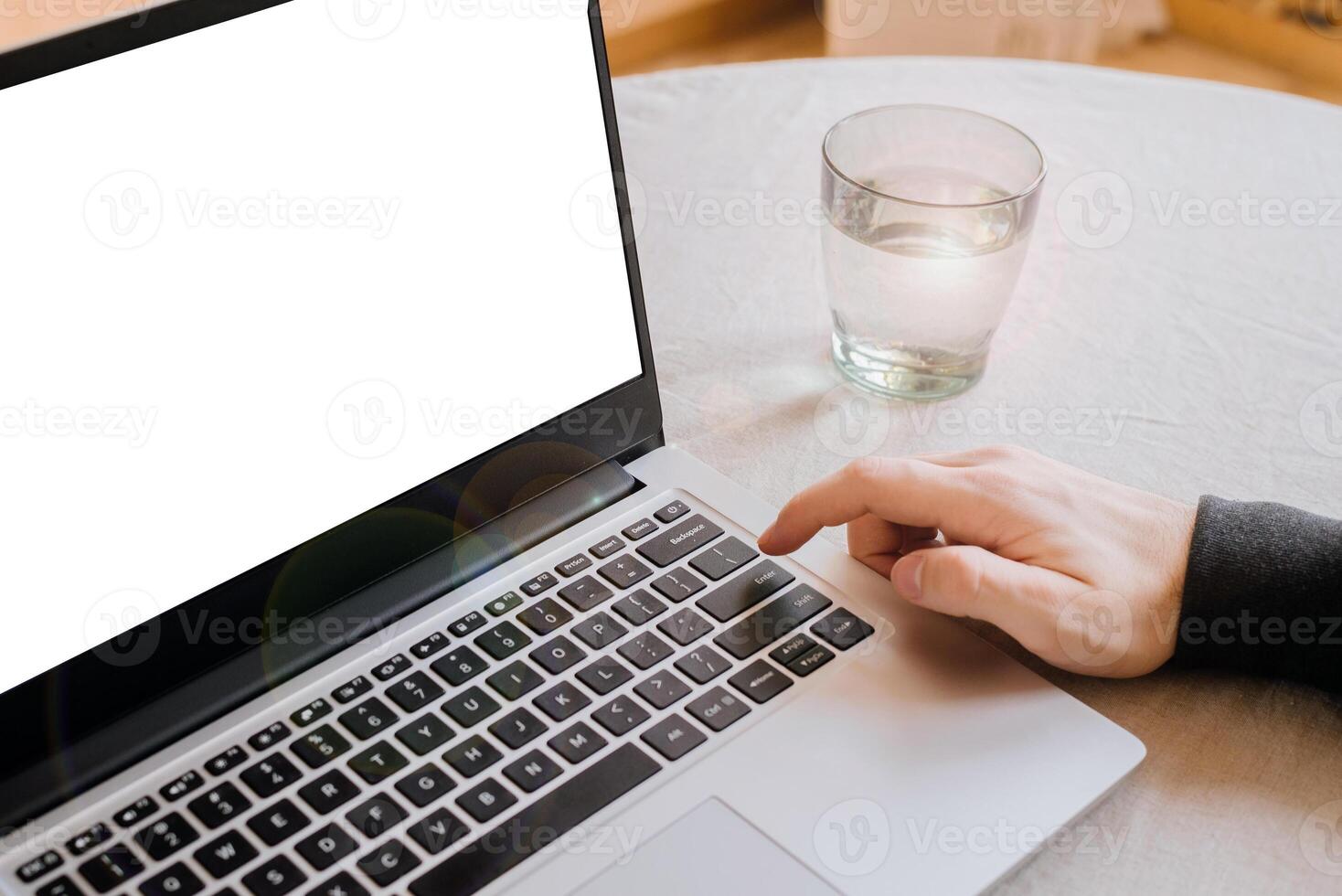 Closeup image of a man finger pressing on the enter button of laptop computer on the table. space for text. telework. freelance photo