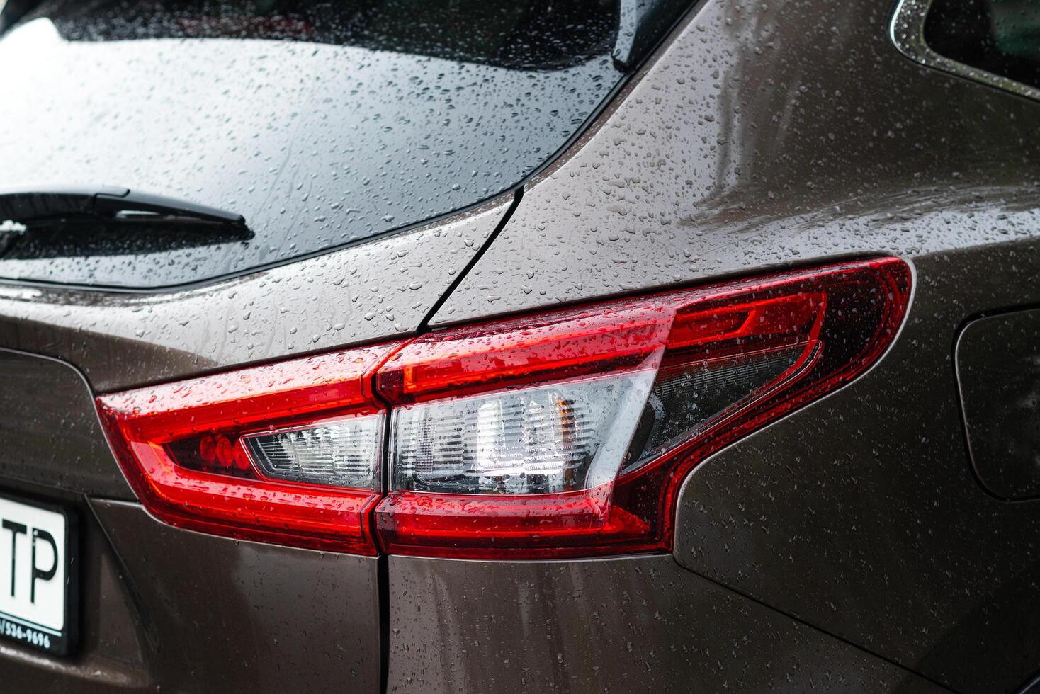 Nissan Qashqai, Macro view of modern car xenon lamp taillight. Exterior of a modern car with water drops photo