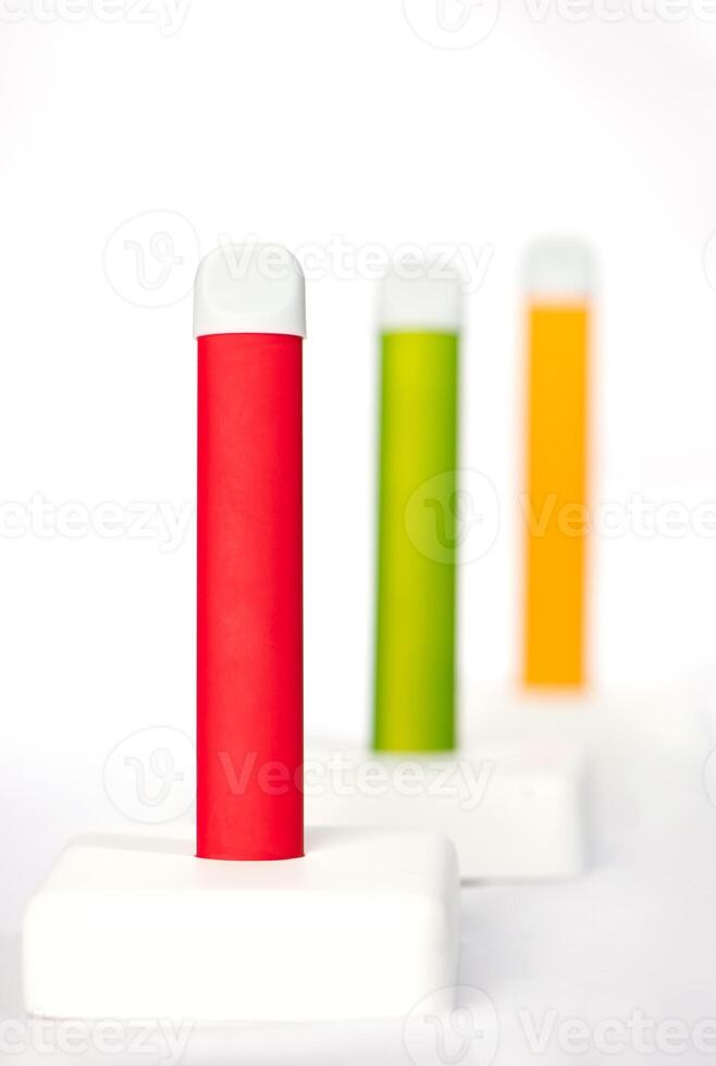 Set of colorful disposable electronic cigarettes on a display stand on a white background. The concept of modern smoking, vaping and nicotine. photo