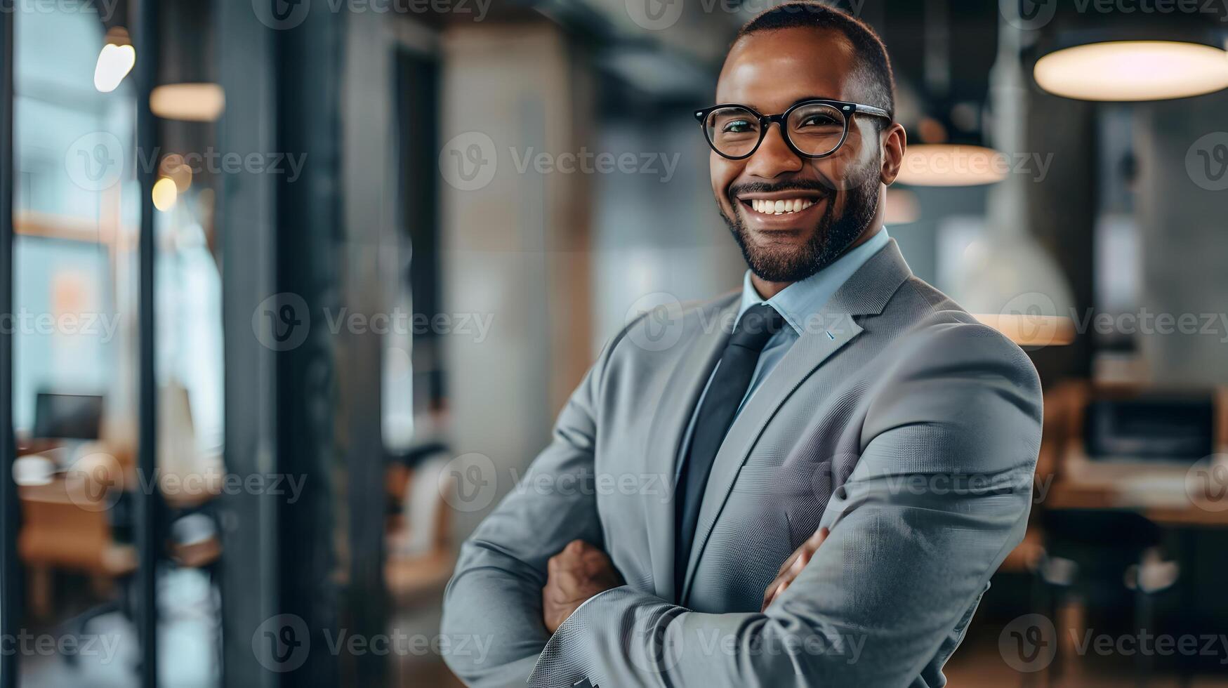 portrait of smiling african american businessman in eyeglasses with crossed arms in cafe photo