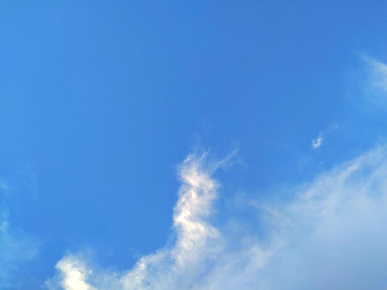 Looking straight up at the the sky. Thin clouds pattern with blue sky as background photo