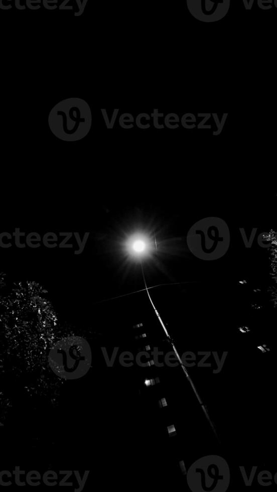 A single post light glowing in an extreme dark area photo