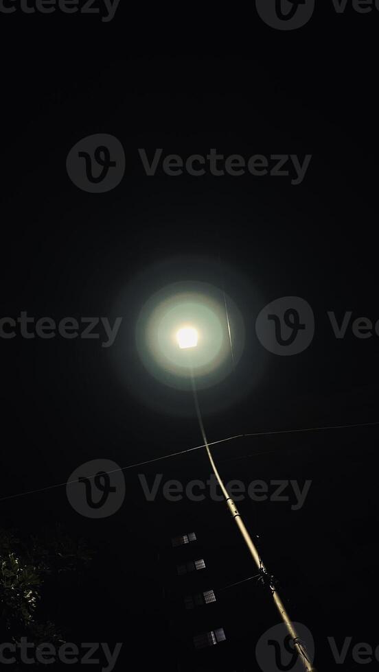 Clear night view of a tallest post light placed in front of the largest apartment photo