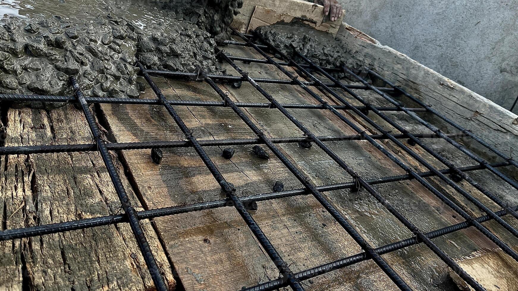 Wet concrete was applied to make the concrete slab over the connected steels photo