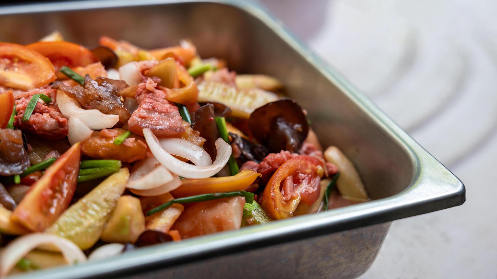 Close-up view of sweet and sour stir fry filled with pork pieces. photo