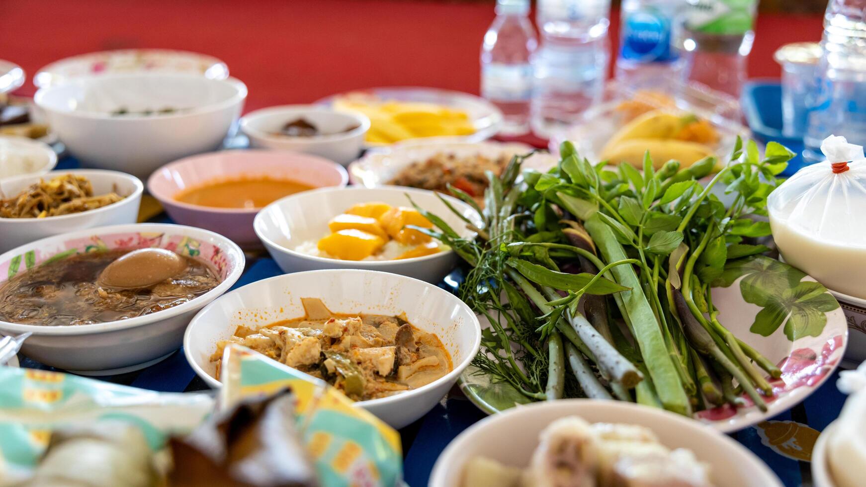 Close-up view of boiled eggs, curry, boiled, stir-fried and many other dishes packed in bowls. photo