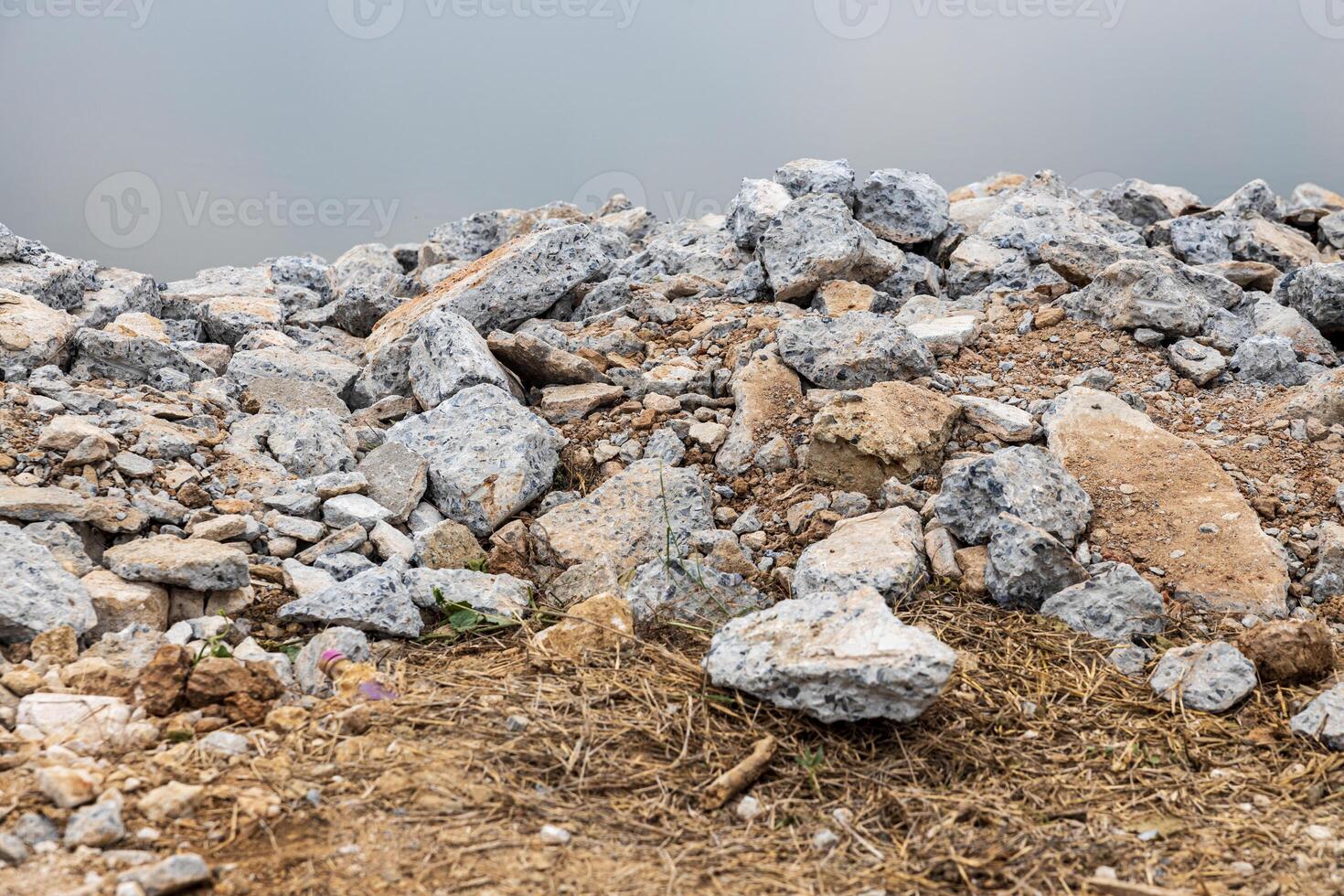 Piles of broken concrete debris taken from road demolition are left on a mound. photo
