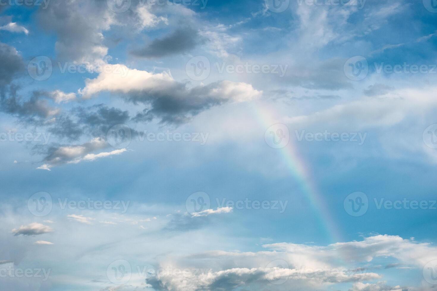 Arch rainbow natural phenomenon with clouds in sky photo
