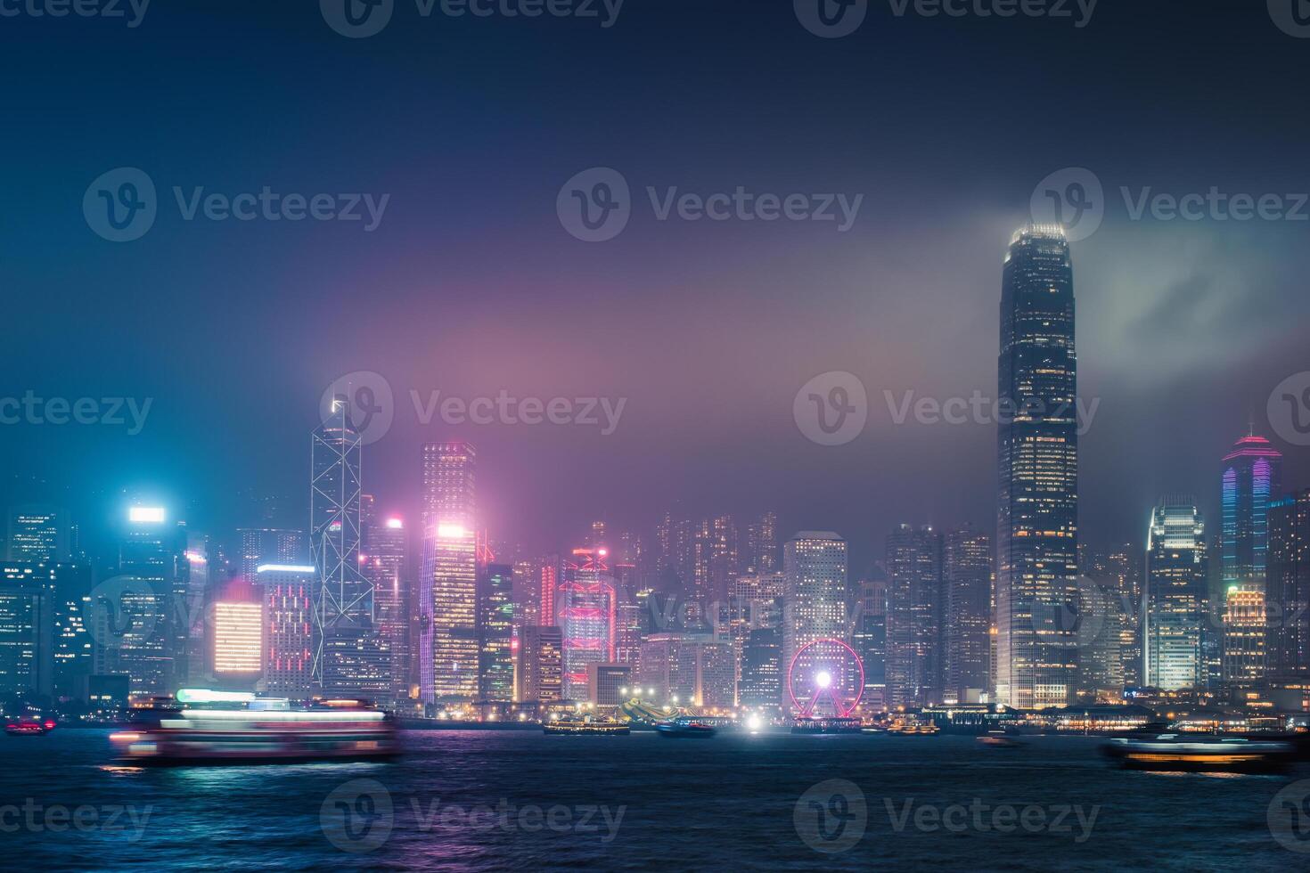 Colorful illuminated skyscraper building with laser lighting show on Victoria Harbour at Hong Kong island photo