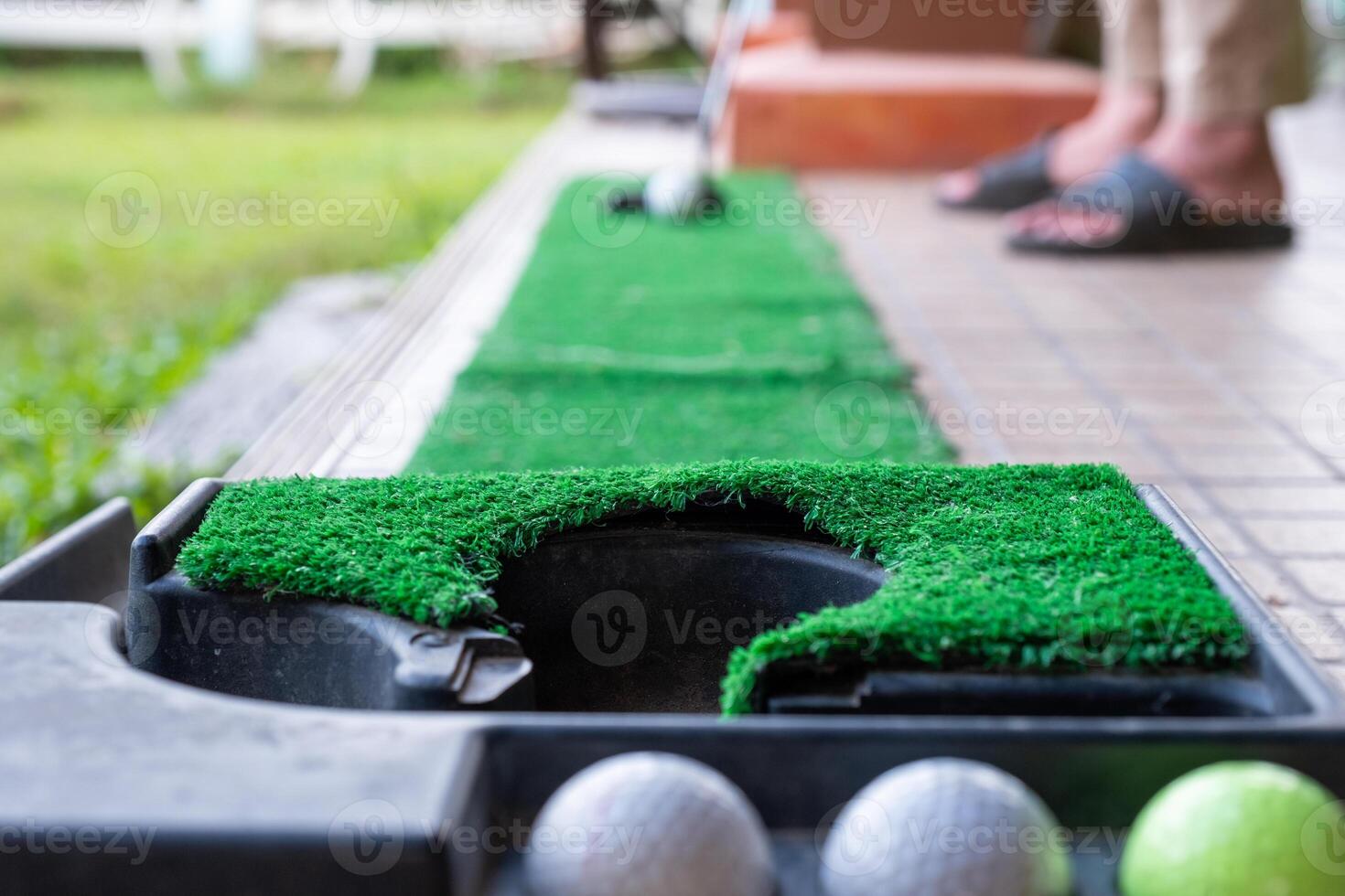 Golfer preparing on training putt with golf ball photo