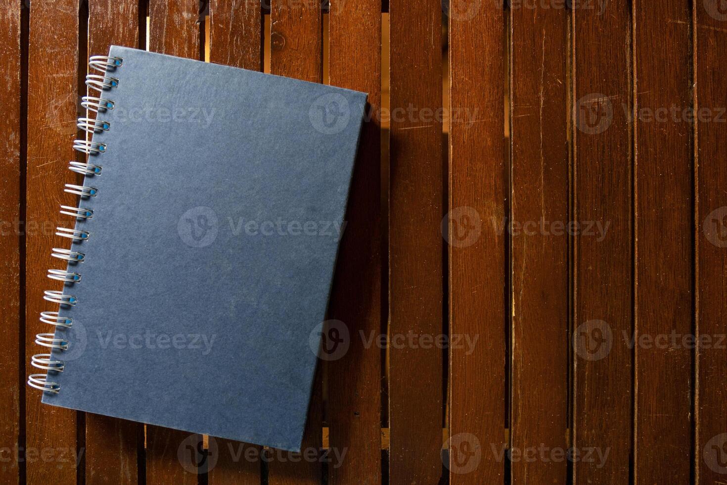 Closed hardcover book on wooden table photo