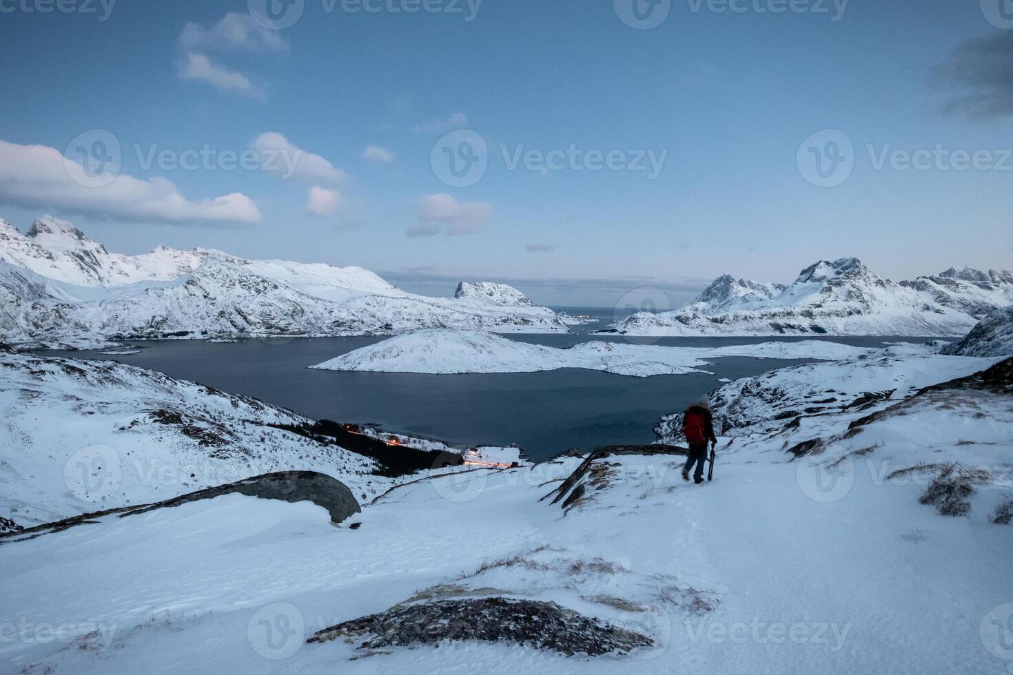 Climber lost on snowy mountain with sky on arctic ocean photo