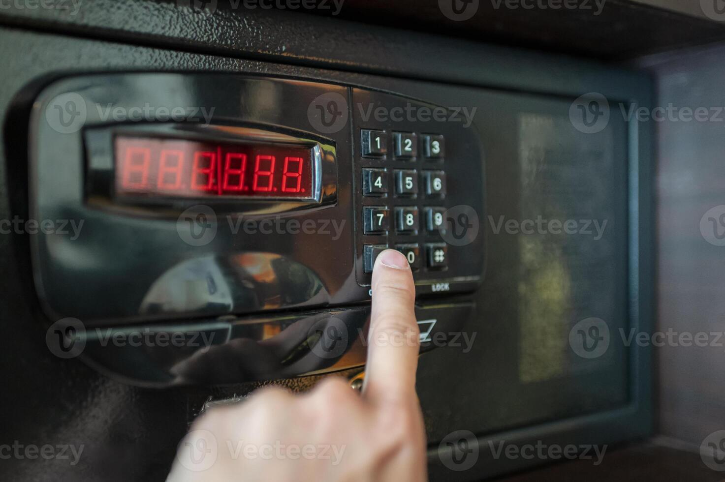 Finger are pressing the number keys of electric safe photo