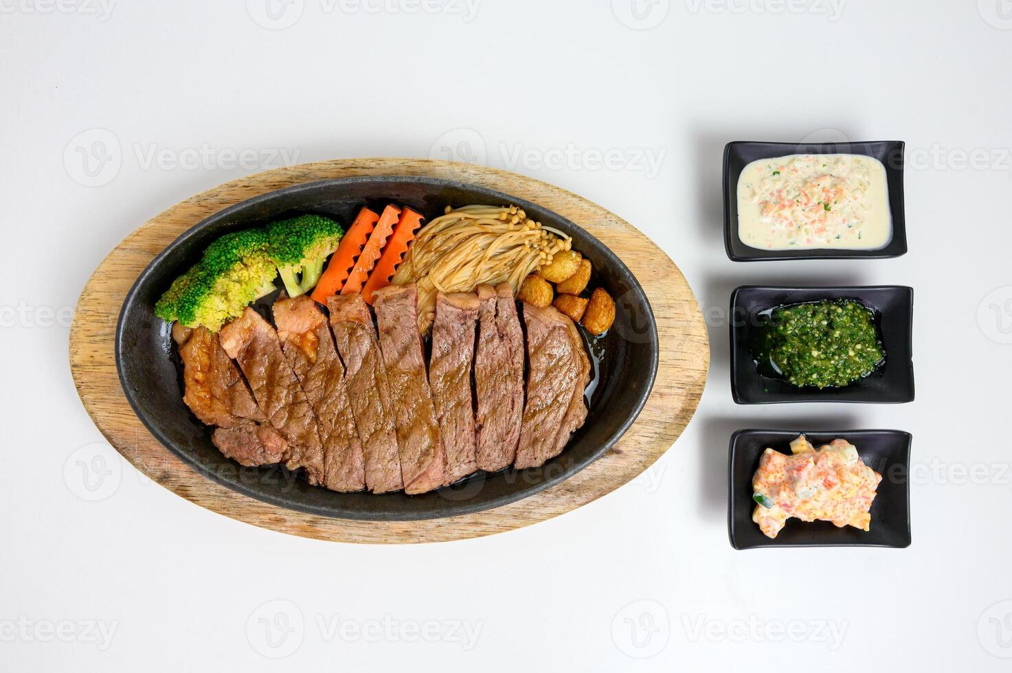Japanese wagyu beef slices set with vegetables and sauce on wooden tray photo