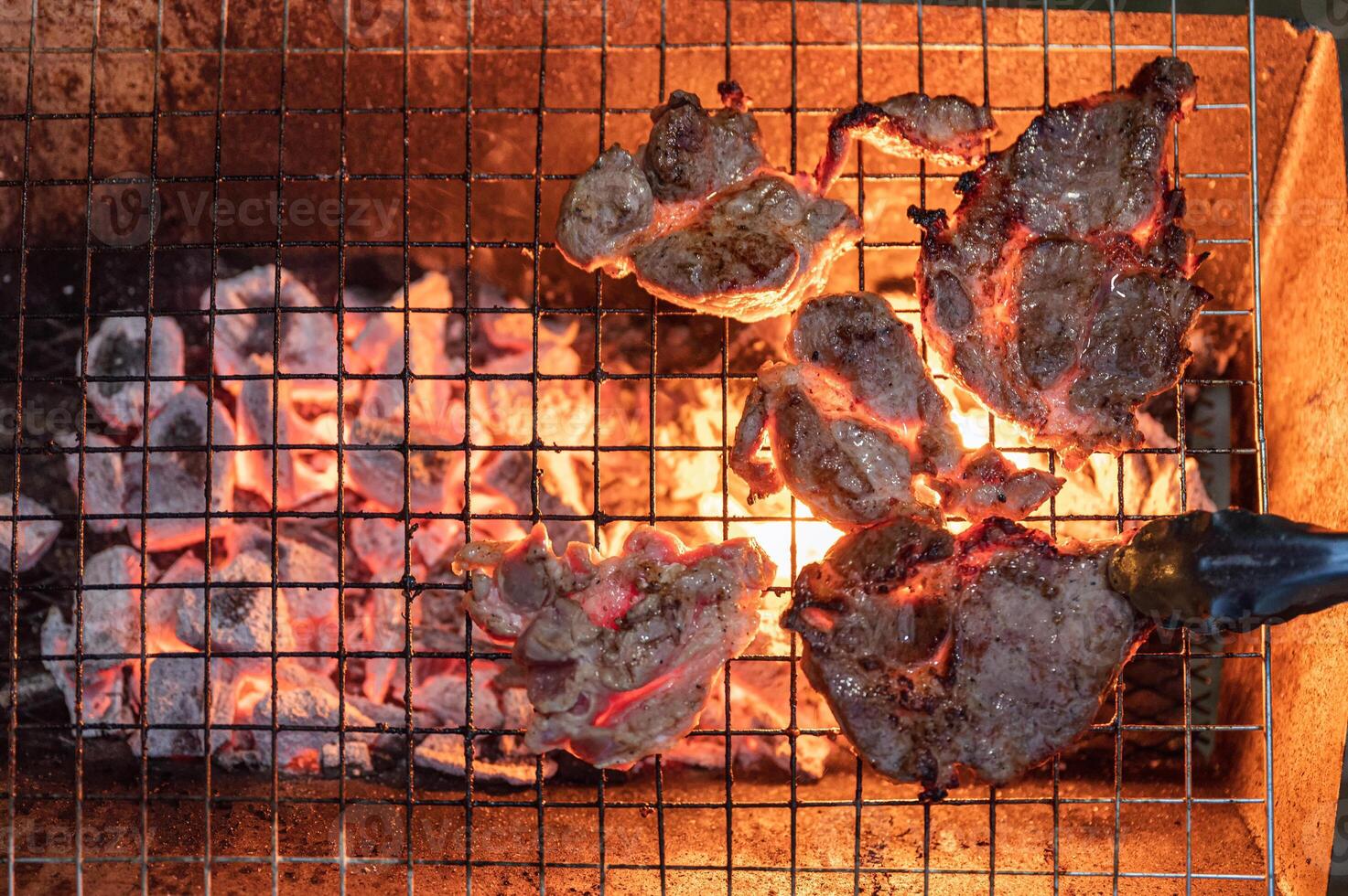 Grilled marinated pork on charcoal grill in dinner photo