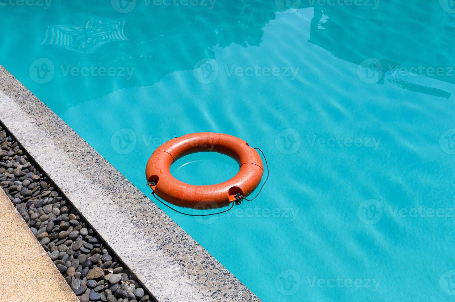 Orange lifebuoy floating on surface swimming pool photo