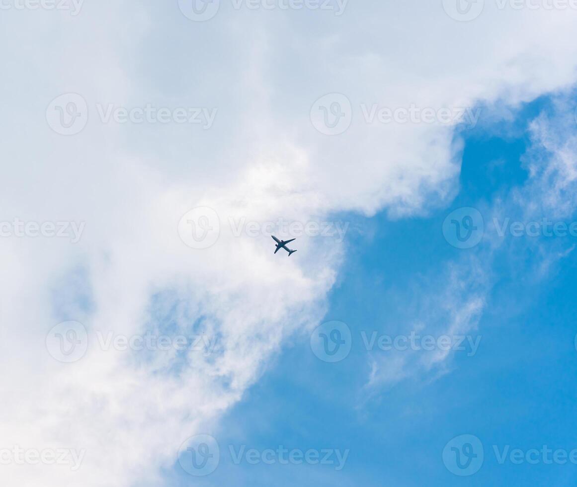 Airplane flying in the sky with white clouds photo
