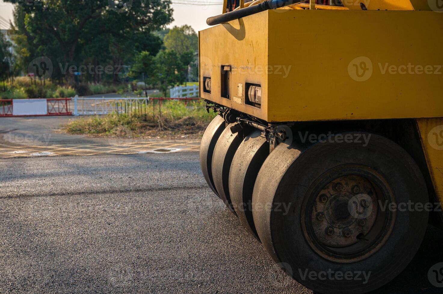 Heavy vibration yellow steamroller or soil compactor working on hot-mix asphalt pavement road photo