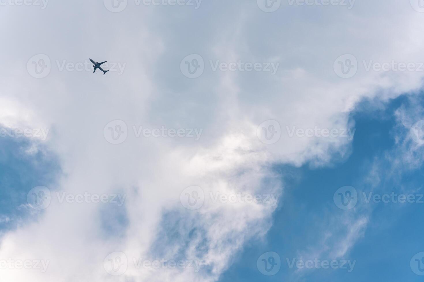 Airplane flying in the sky with white clouds photo