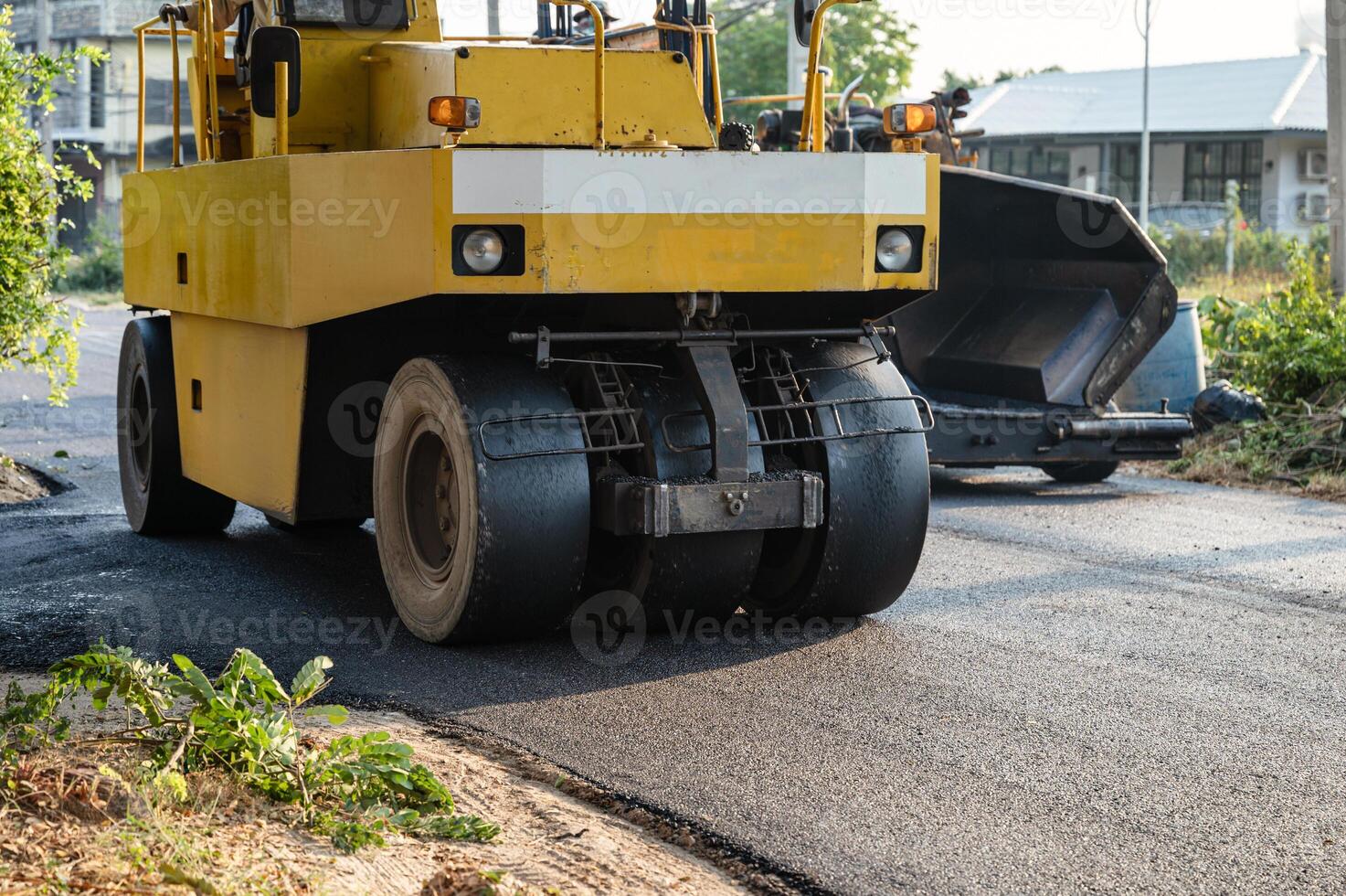 Heavy vibration yellow steamroller or soil compactor working on hot-mix asphalt pavement road photo