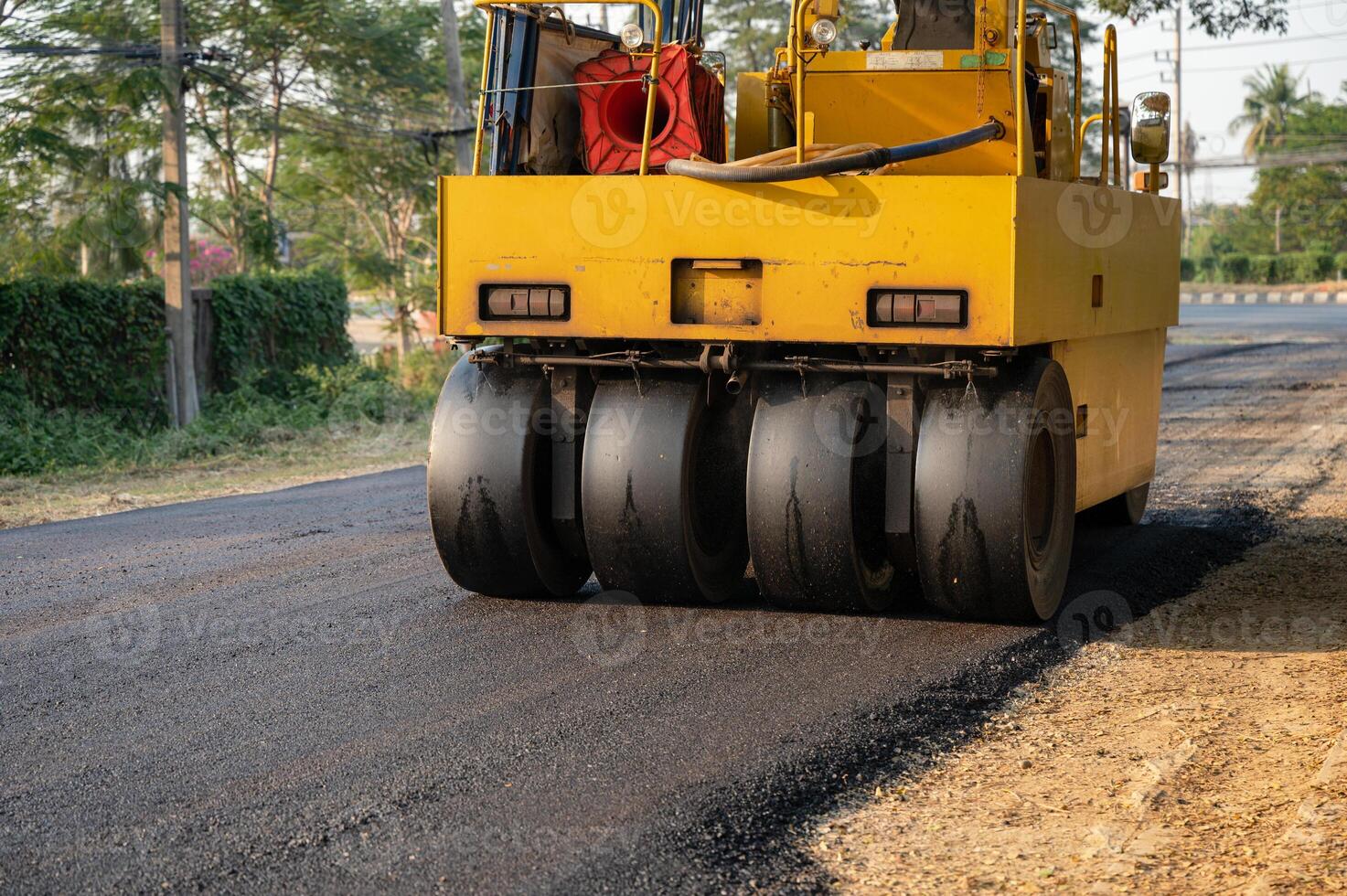 Heavy vibration yellow steamroller or soil compactor working on hot-mix asphalt pavement road photo