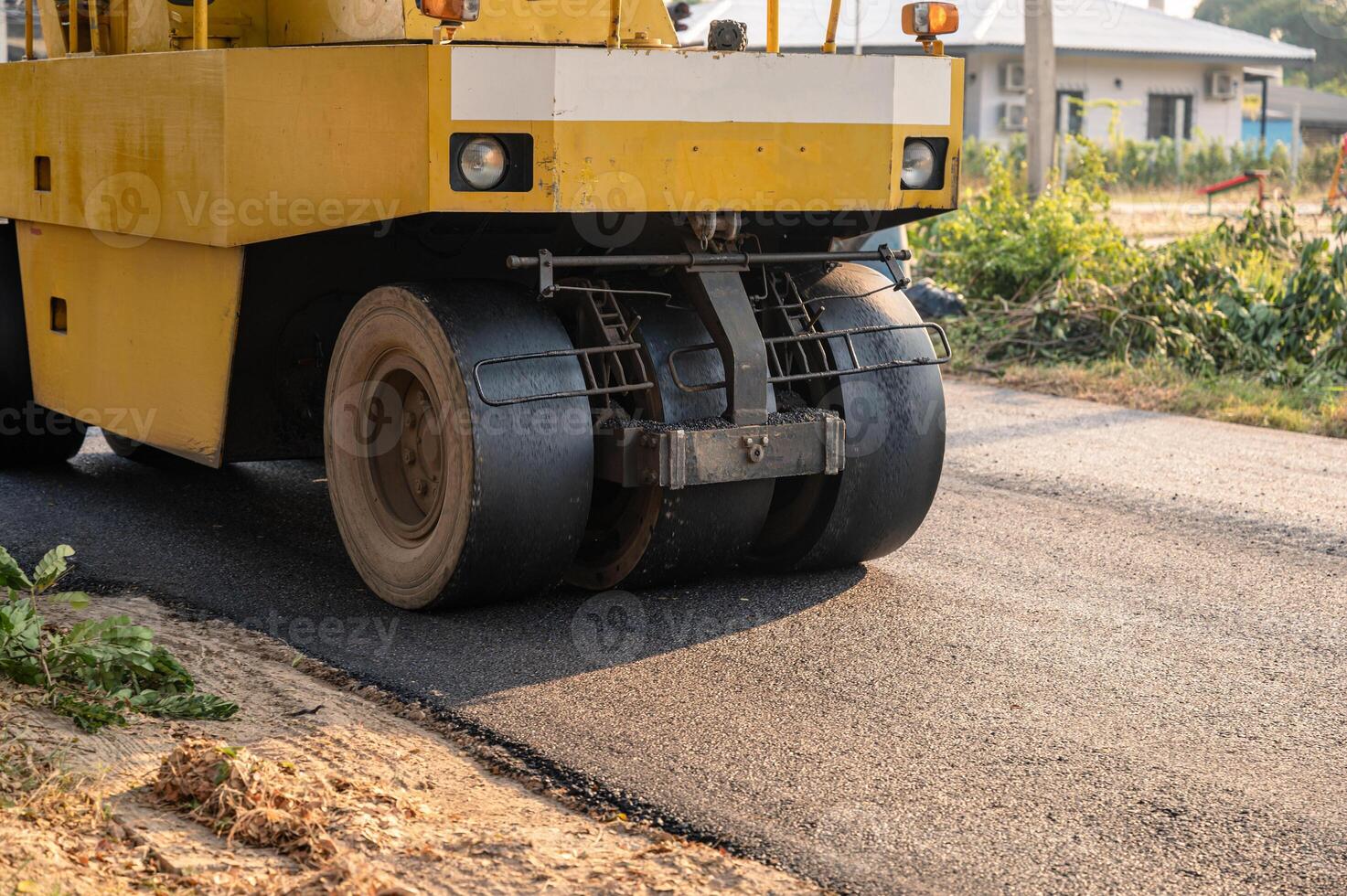 Heavy vibration yellow steamroller or soil compactor working on hot-mix asphalt pavement road photo