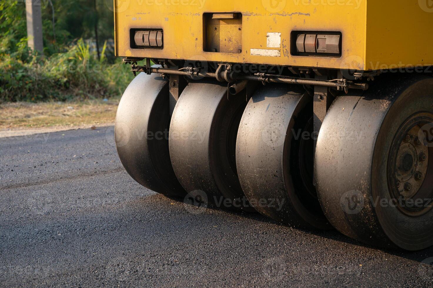 Heavy vibration yellow steamroller or soil compactor working on hot-mix asphalt pavement road photo